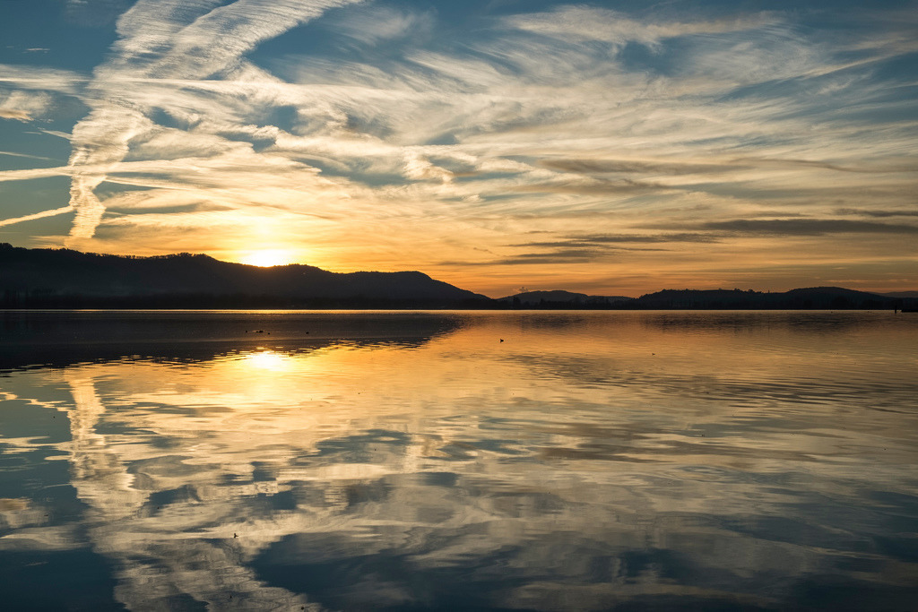 Wolkenmalerei | Kondensstreifen und Federwolken bilden ein einzigartiges Kunstwerk in den Himmel und den Zeller See - Realisiert mit Pictrs.com