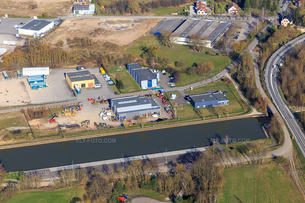 Aerial view: Industrial area by the canal with Somatec Manutention and Apm in Dettwiller in the state Bas-Rhin, France. – Photo: IMG_097553.jpg taken on 03/16/2017 by Werner Riehm/FLY-FOTO.com – Resolution of the original: 5472 x 3648 px – Somatec manutention : | SOMATEC – APM