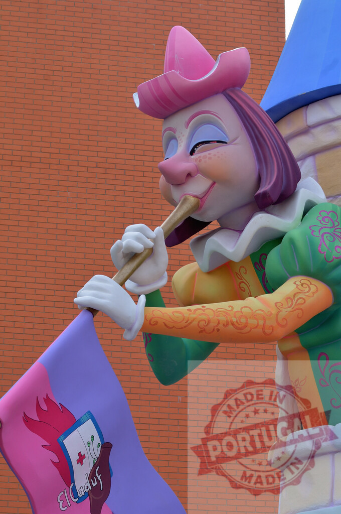 Colorful Fallas ninot playing instrument and holding flag. Fallas Fiestas Communidad Valenciana | Colorful Fallas ninot sculpture playing a wind instrument and holding the El Caduf flag - Realisiert mit Pictrs.com