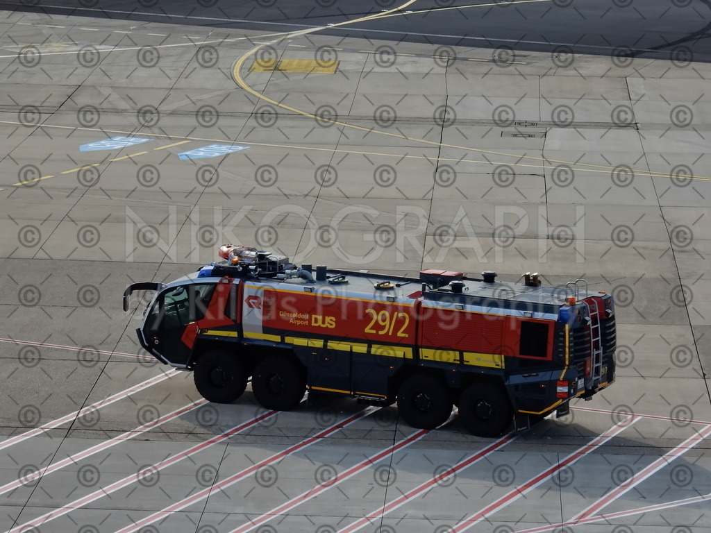 Flugfeldlöschfahrzeug | Das Flugfeldlöschfahrzeug vom Typ Rosenbauer Panther 8x8 der Flughafenfeuerwehr auf dem Vorfeld des Flughafens Düsseldorf. Das Löschfahrzeug kann 12.500 Liter Wasser, 1.500 Liter Schaummittel und 500 kg Löschpulver binnen kürzester Zeit zur Einsatzstelle bringen.Das Foto ist ein ideales Wandbild für Feuerwehrfreunde und Flugenthusiasten und kann auf Nikograph.eu direkt online bestellt werden. 