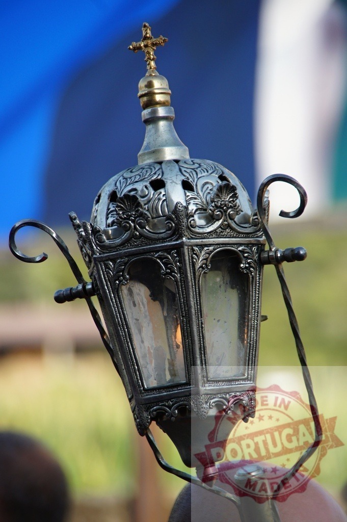 Ornate silver lantern with cross and flame light | Ornate silver metal lantern with a religious cross and burning flame inside - Realisiert mit Pictrs.com