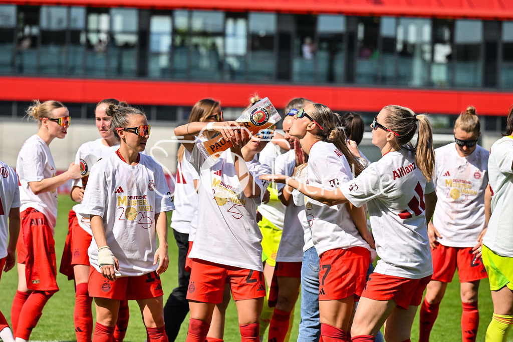 FC Bayern München - SC Freiburg | Die Spielerinnen des FC Bayern feiern die Meisterschaft nach dem Heimsieg gegen den SC Freiburg / Frauen Bundesliga: FC Bayern Muenchen - SC Freiburg, FC Bayern Campus am 27.04.2025 / Arianna CARUSO (FC Bayern Muenchen Frauen 27) gibt Klara BUEHL (FCB #17) einen Schluck auf dem Paulaner Bierkrug / Bierglas