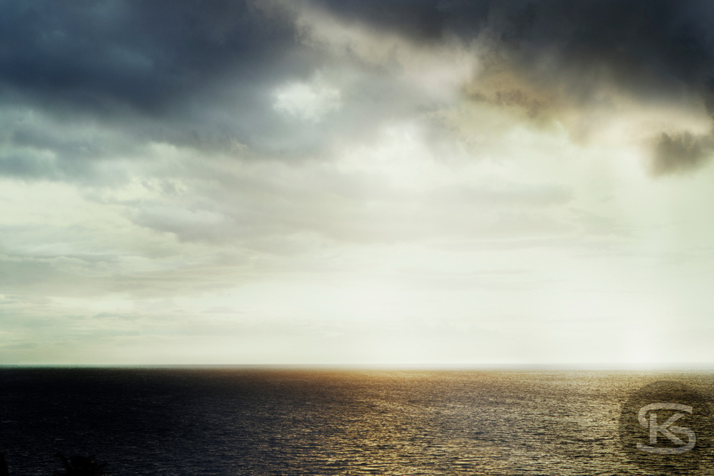 Dramatische Meereslandschaft bei Sonnenaufgang, bedeckter Himmel | Tauchen Sie ein in die dramatische und fesselnde Schönheit dieser Meereslandschaft. Der Kontrast zwischen den dunklen Gewitterwolken und dem hellen Sonnenlicht, das auf die Wasseroberfläche fällt, schafft eine intensive Atmosphäre und ein faszinierendes Lichtspiel am Horizont. - Realisiert mit Pictrs.com