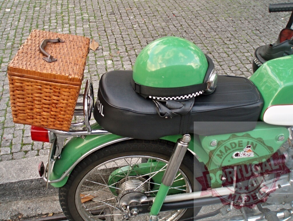 Green motorcycle with wicker basket and helmet parked on cobblestone street | Retro green motorcycle with wicker basket and helmet parked on a cobblestone street, ready for an adventure - Realized with Pictrs.com
