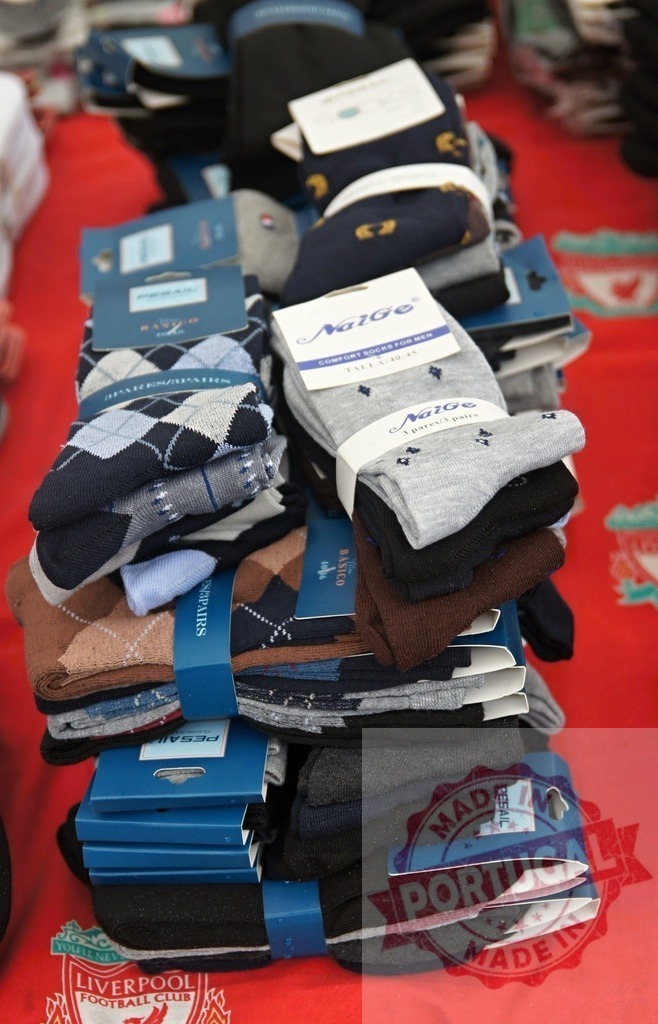 Stacks of patterned men's socks for sale | Bundles of men's socks arranged on a table for retail display - Realized with Pictrs.com