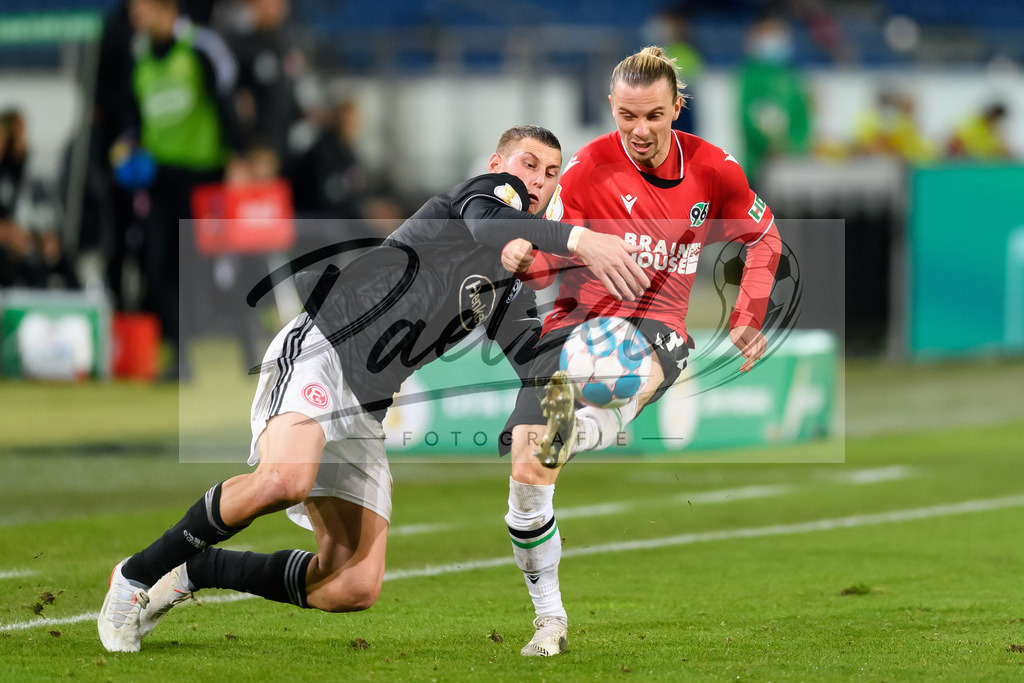 H96DUS20211027_060 | Fussball, Herren: Jakub Piotrowski (Fortuna Duesseldorf) und Niklas Hult (Hannover 96) im Zweikampf bei dem Spiel der 2. Runde im DFB-Pokal zwischen Hannover 96 und Fortuna Duesseldorf in der HDI-Arena am 27.10.2021 in Hannover, Deutschland.DFB / DFL REGULATIONS PROHIBIT ANY USE OF PHOTOGRAPHS AS IMAGE SEQUENCES AND/OR QUASI-VIDEO. - Realisiert mit Pictrs.com