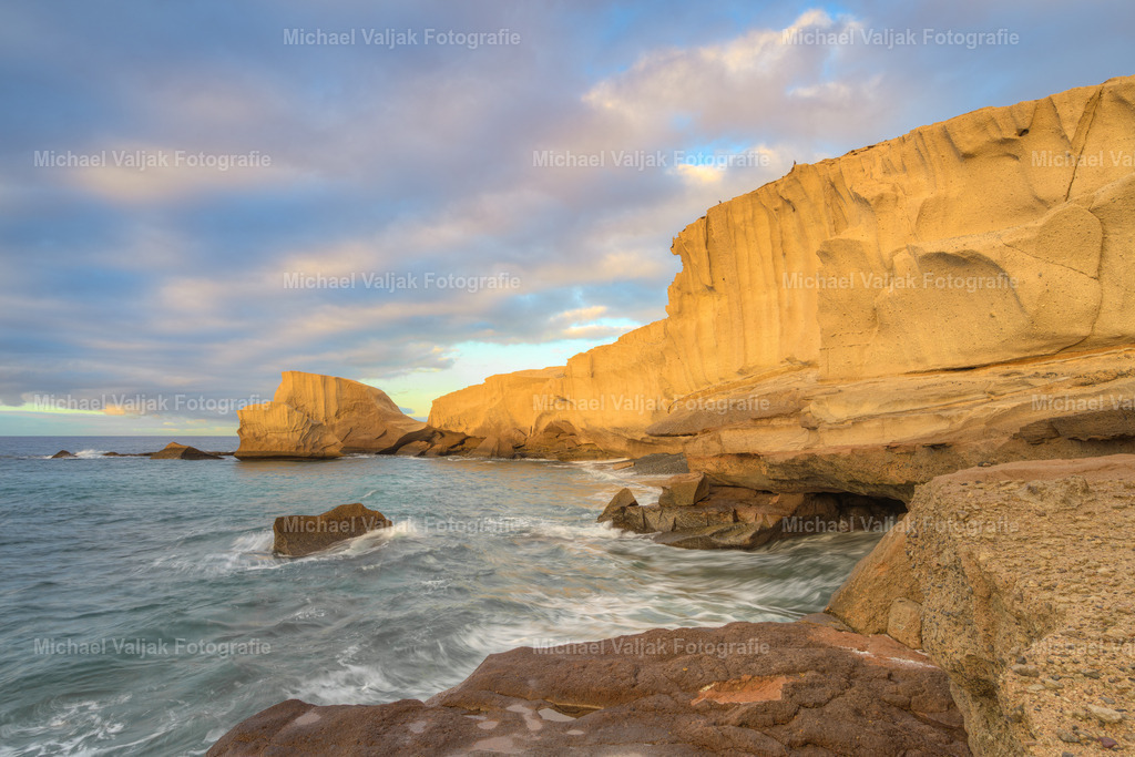 Teneriffa Los Roques de Tajao | Die Los Roques de Tajao bieten ein atemberaubendes Naturschauspiel auf Teneriffa, besonders im sanften Morgenlicht. Diese vulkanischen Formationen, die durch Erosion über Jahrtausende hinweg geformt wurden, sind ein Zeugnis der natürlichen Schönheit der Kanarischen Inseln. Besucher können den Arco de Tajao, einen beeindruckenden natürlichen Bogen, über einen kurzen, steilen Pfad erreichen und von dort aus einen weiten Blick auf die Küstenlandschaft genießen. Die Gegend ist auch bekannt für ihre malerischen Wanderwege und die authentische lokale Gastronomie, die frischen Fisch und Meeresfrüchte anbietet. - Realisiert mit Pictrs.com
