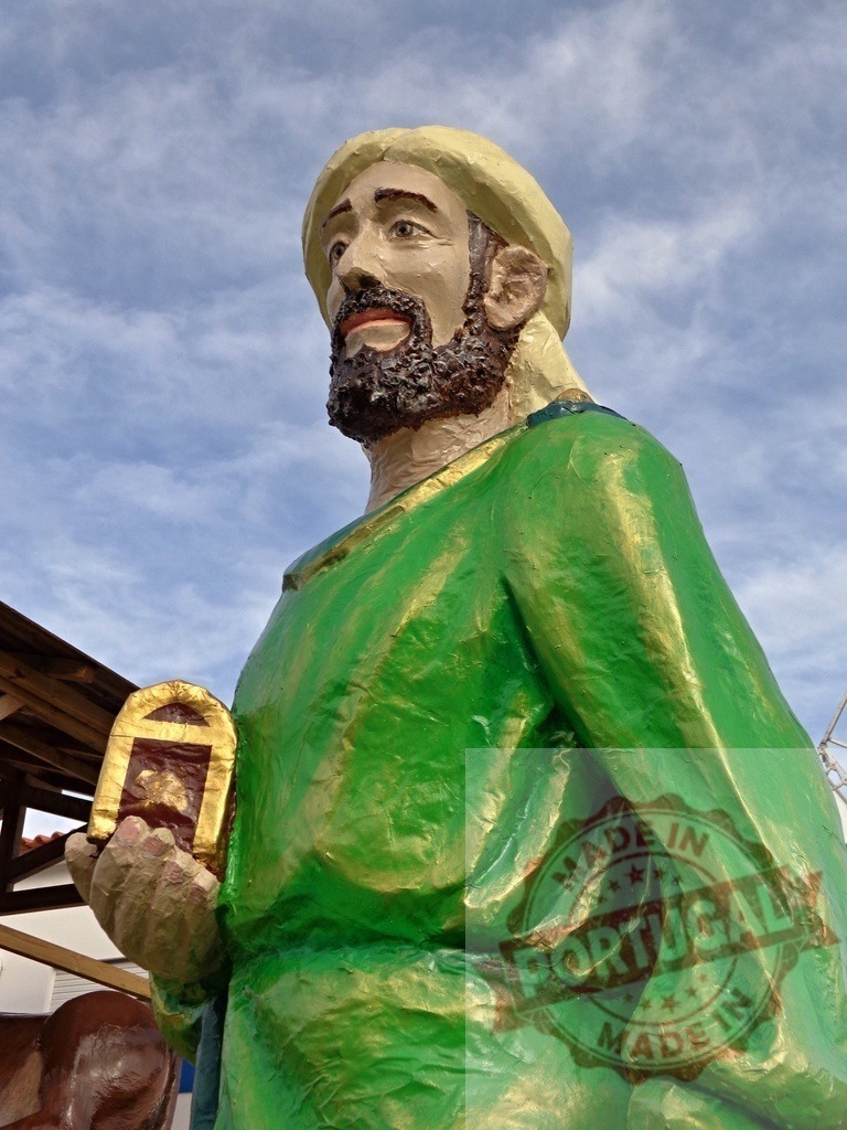Statue of Saint Jude Thaddeus holding a small golden shrine | Colorful statue of Saint Jude Thaddeus holding a small golden shrine against a cloudy sky - Realisiert mit Pictrs.com