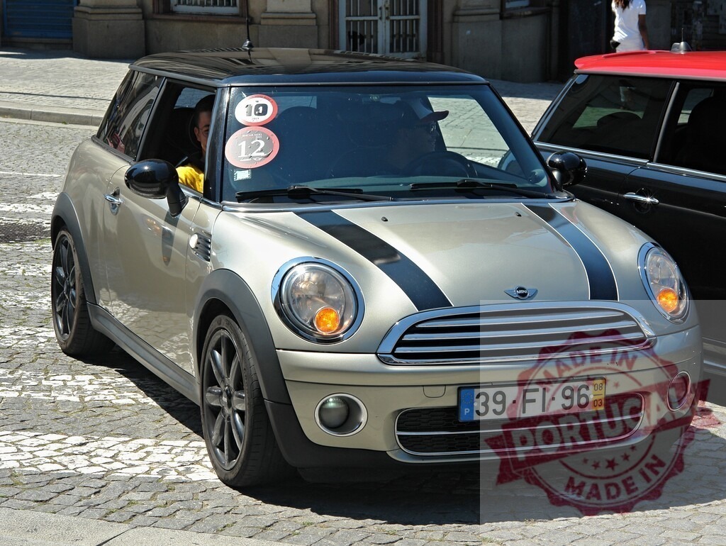 Mini Cooper parking on cobblestone street with driver | Silver Mini Cooper with black stripes parked on a cobblestone street with a driver inside - Realisiert mit Pictrs.com