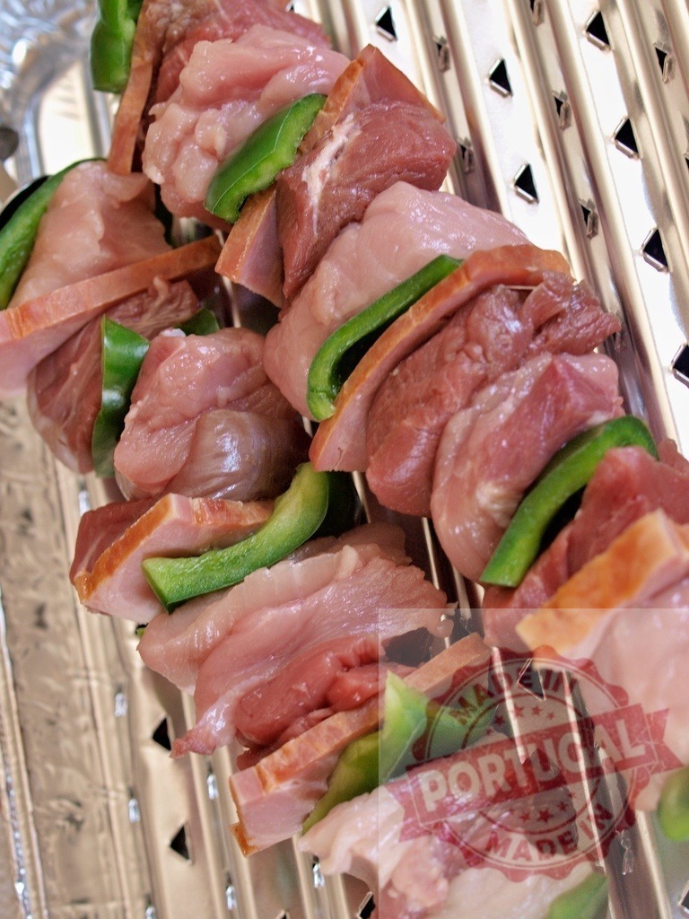 Raw meat skewers with pork, bacon, and bell pepper | Raw meat and green bell pepper skewers arranged on a silver grill rack, ready for cooking - Realisiert mit Pictrs.com