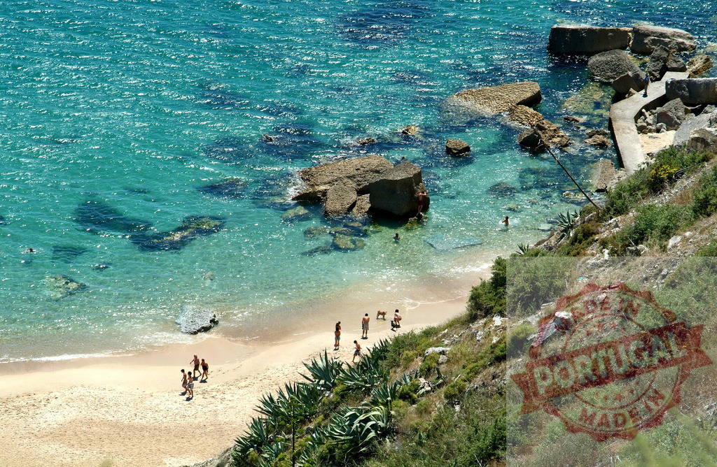 People enjoying clear turquoise sea on a sunny beach | People swimming and relaxing on a sandy beach by a clear turquoise sea with rocks - Realized with Pictrs.com