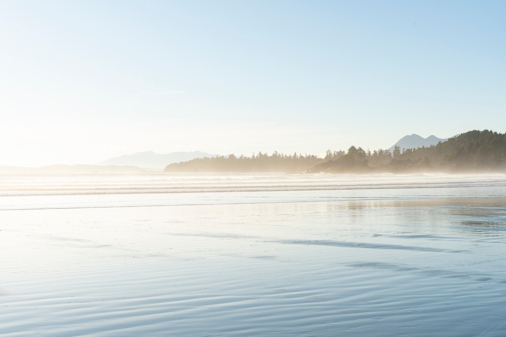 Licht und Stille – Cox Bay Beach, Kanada | Ein heller, ruhiger Strand auf Vancouver Island bei sanftem Licht. Der feine Nebel über dem Wasser sorgt für eine weiche, zurückhaltende Stimmung. Ein Bild, das Ruhe und Weite ausstrahlt. - Realisiert mit Pictrs.com