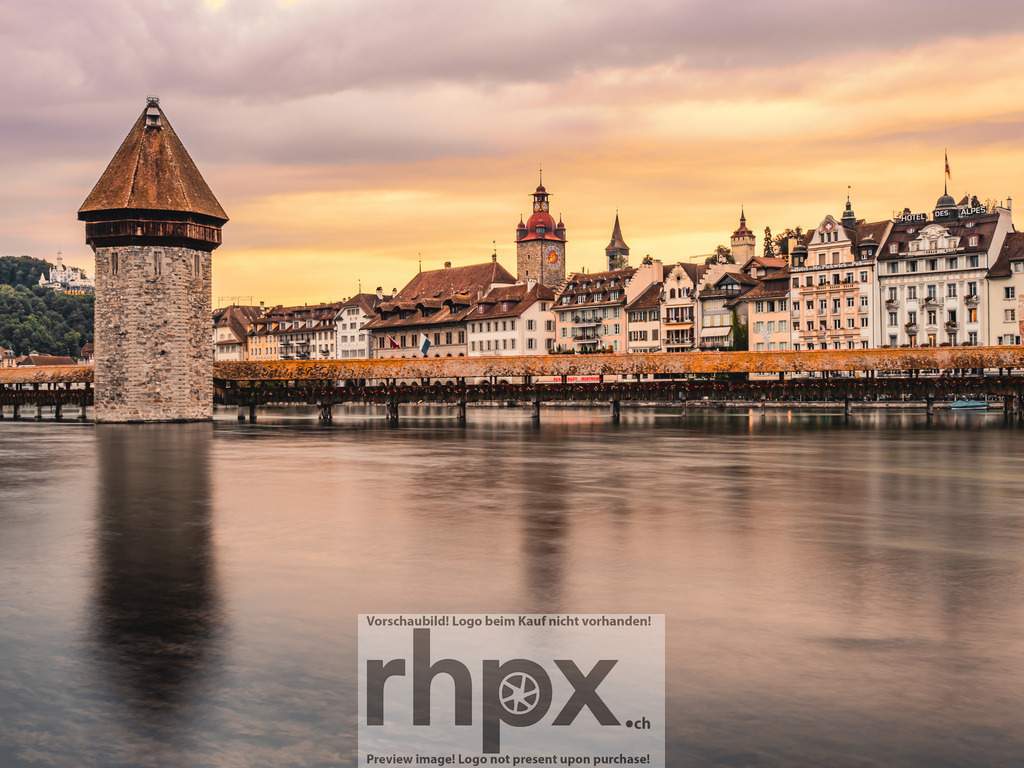 Kapellbrücke im Abendlicht | Wahrzeichen. Abendlicht. Geschichte.
Die historische Kapellbrücke in Luzern präsentiert sich in sanftes, warmes Abendlicht getaucht. Ruhig spiegelt sich der markante Wasserturm in der Reuss und strahlt zusammen mit der Altstadt eine zeitlose Eleganz aus.
Wähle unter "Produktauswahl" dein Wunschformat: Vom klassischen Wandbild über Puzzle &amp; Tassen bis zum digitalen Download (z.B. als Handy-Hintergrund).

 - Realisiert mit Pictrs.com