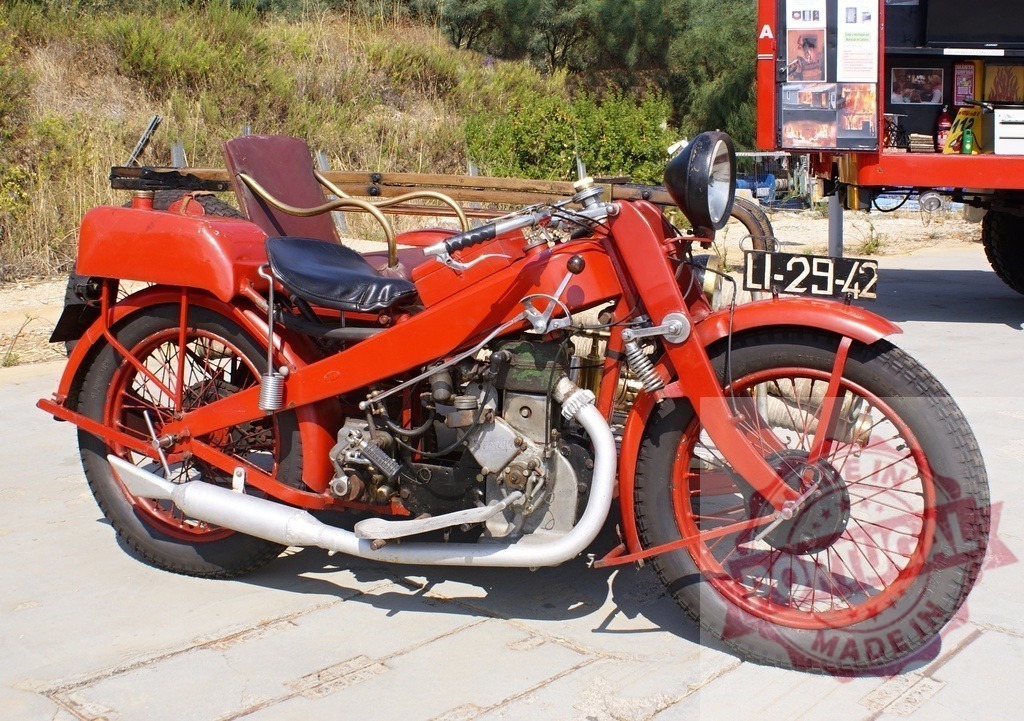 Red vintage motorcycle with sidecar parked outdoors | Red vintage motorcycle with a sidecar and a ladder on the back, displaying an old license plate - Realisiert mit Pictrs.com