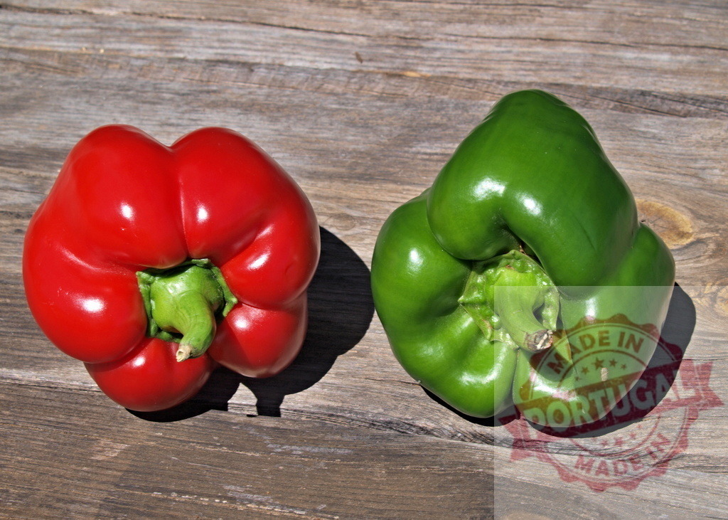 Red and green bell peppers resting on wood surface | Two fresh bell peppers, one red and one green, creating a colorful contrast - Realized with Pictrs.com