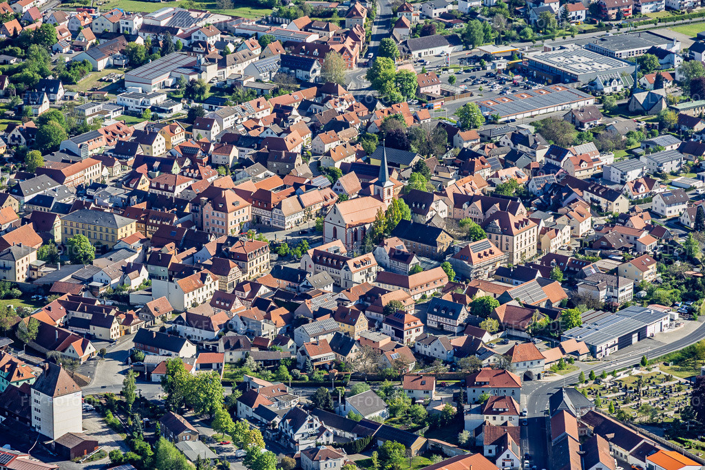 Luftbild: Marktplatz mit Stadtpfarrkirche St. Johannes der Täufer in Hofheim in Unterfranken im Bundesland Bayern in Deutschland. – Foto: IMG_155219.jpg vom 02.05.2026 durch Werner Riehm/FLY-FOTO.de – Auflösung des Originals: 6000 x 4000 px – PG Hofheim: PG Hofheim