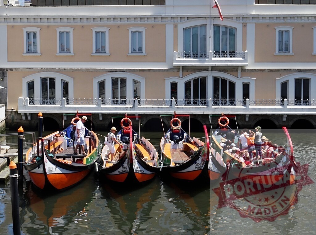 Moliceiro tour boats in Aveiro canal waterway. Aveiro - Portugal | Aveiro, Portugal: Moliceiro boats carrying tourists on a canal in summer - Realized with Pictrs.com