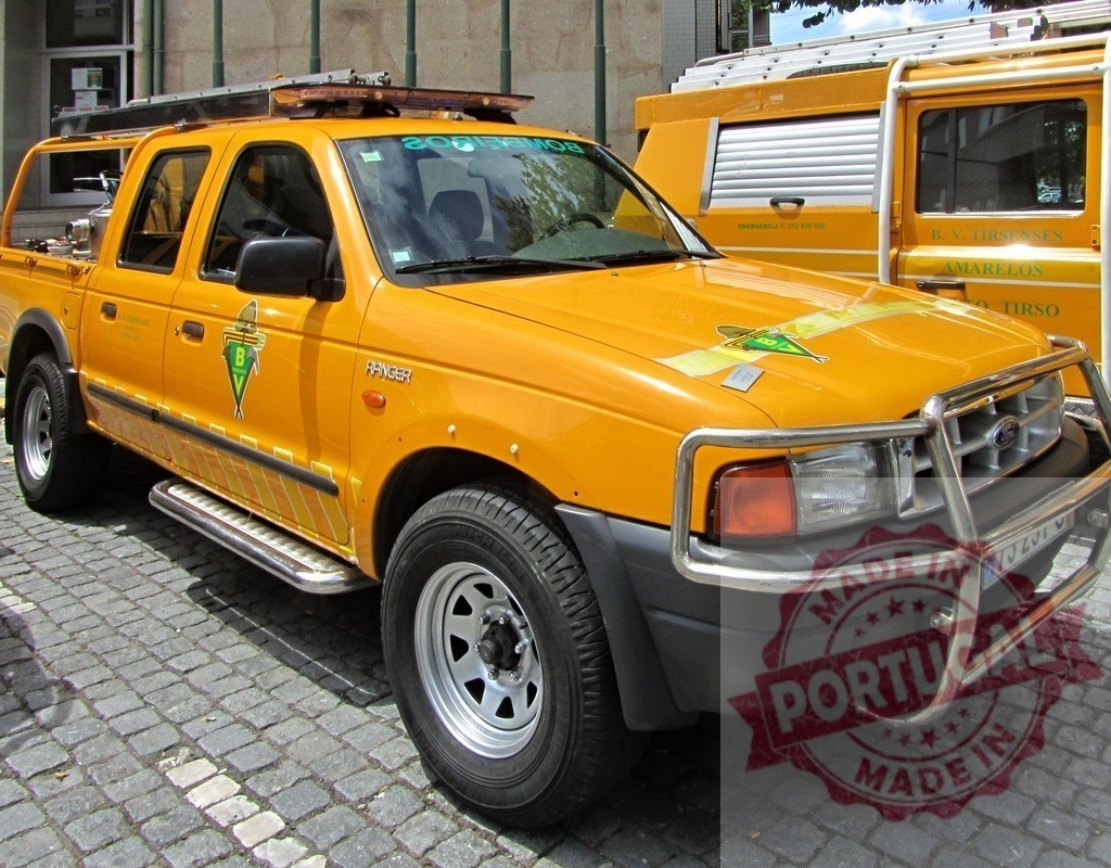 Yellow Ford Ranger pickup truck for emergency services | Yellow Ford Ranger pickup truck parked on a cobblestone street, ready for emergency operations - Realized with Pictrs.com