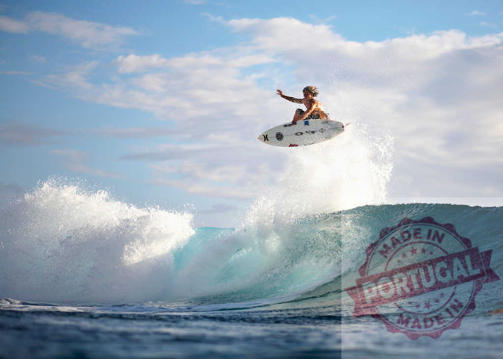 Surfer jumping with surfboard over a big wave in the ocean during a surfing competition | Professional surfer performing an aerial maneuver during a surfing competition in the ocean - Realisiert mit Pictrs.com