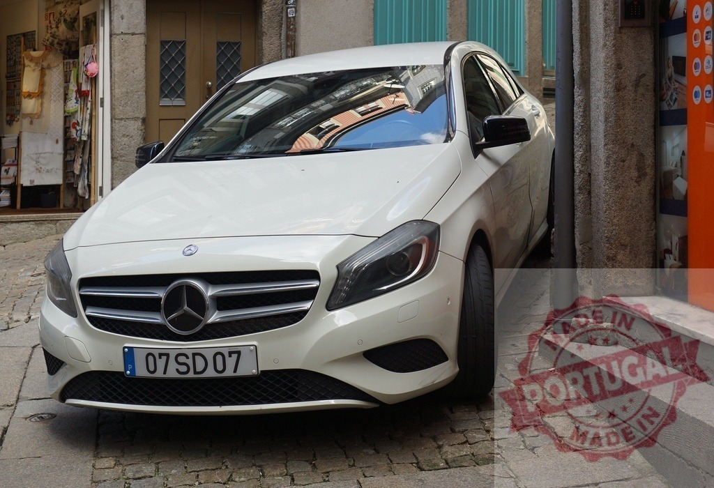 Mercedes-Benz A class car parked on old street | White Mercedes-Benz A-Class car parked on a narrow cobblestone street next to buildings - Realisiert mit Pictrs.com