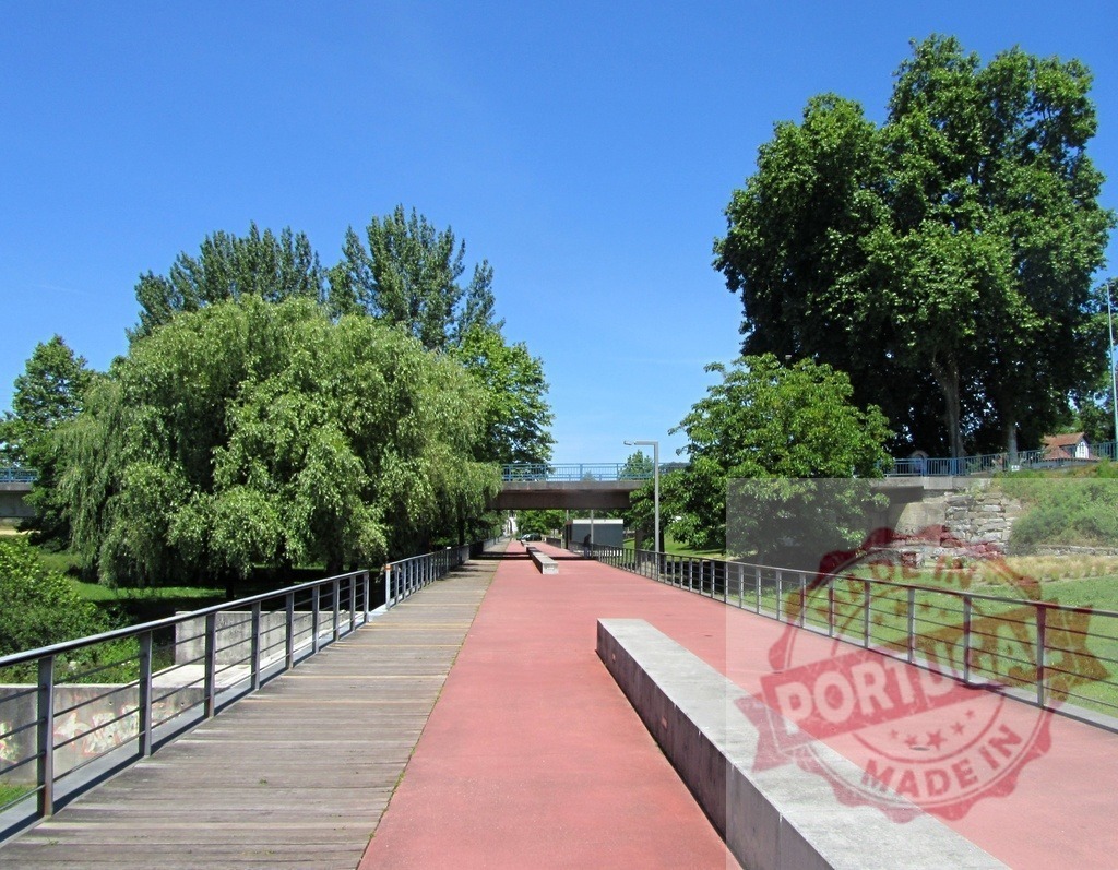 City park red path and wooden promenade. Portugal - Norte | City park featuring a long red pathway beside a wooden promenade under clear blue skies - Realisiert mit Pictrs.com