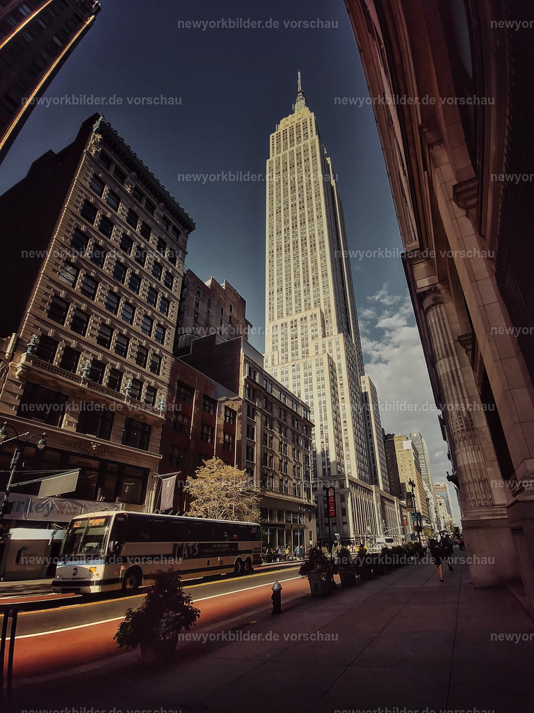 Empire State Building von unten – Ikonisches Wahrzeichen in Manhattan | Am Fuße des Empire State Building spürt man die Größe und Geschichte dieses Wahrzeichens. Die gewaltigen Linien ziehen den Blick nach oben, während der Himmel dahinter die perfekte Bühne für die Eleganz des Art-Déco-Stils bildet. Ein Moment, der die Kraft und den Charakter von New York in seiner reinsten Form einfängt