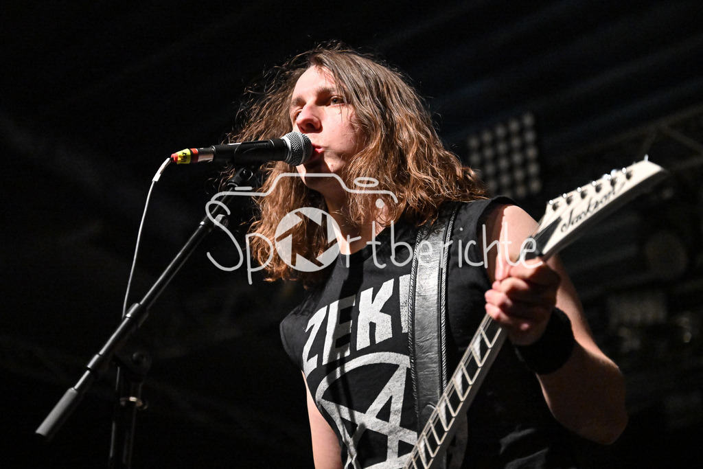 Evil Obsession | Hellripper Frontmann Jamec McBAIN mit Gitarre beim Konzert in Regensburg am Mikrofon / Evil Obsession Part II, Eventhall Airport am 29.12.2024