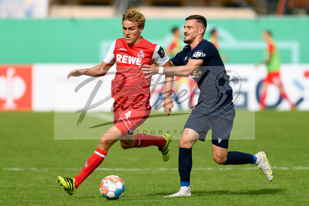 JENKOE20210808_236 | Fussball, Herren: Timo Huebers (1. FC Koeln) und Maximilian Wolfram (FC Carl Zeiss Jena) im Zweikampf beim Spiel der 1. Runde im DFB-Pokal zwischen FC Carl Zeiss Jena und 1. FC Koeln im Ernst-Abbe-Sportfeld am 08.08.2021 in Jena, Deutschland.DFB / DFL REGULATIONS PROHIBIT ANY USE OF PHOTOGRAPHS AS IMAGE SEQUENCES AND/OR QUASI-VIDEO. - Realisiert mit Pictrs.com