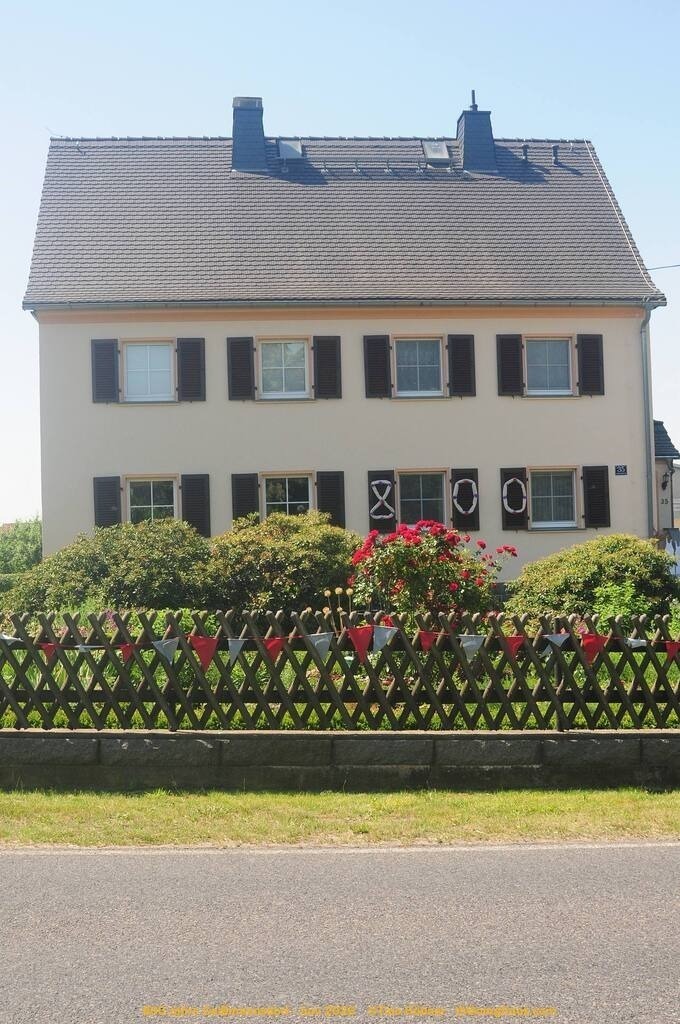 Geißmannsdorf-2026-Ortsbilder-112 | Geißmannsdorf bei Bischofswerda im Sommer 2026. Ein fotografischer Streifzug durch das Dorf Geißmannsdorf, mit Gebäuden, Straßen, Strohpuppen und geschmückten Vorgärten und Grundstücken anlässlich der 800-Jahr-Feier von Geißmannsdorf im Juni 2026 - Realisiert mit Pictrs.com
