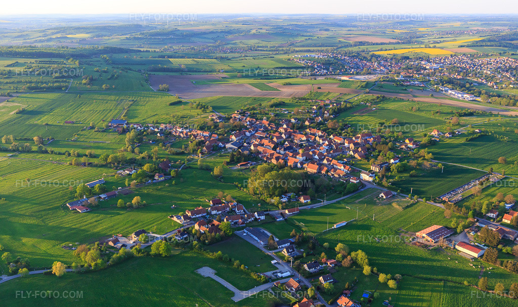 Aerial view: Village view from the southwest in Mackwiller in the state Bas-Rhin, France. – Photo: IMG_145867.jpg taken on 04/30/2025 by Werner Riehm/FLY-FOTO.com – Resolution of the original: 5472 x 3251 px
