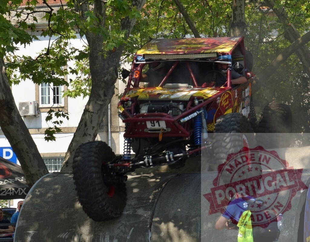 Buggy climbing a concrete pipe during an off-road race | Off-road buggy climbing a concrete pipe during a race, watched by a photographer - Realized with Pictrs.com