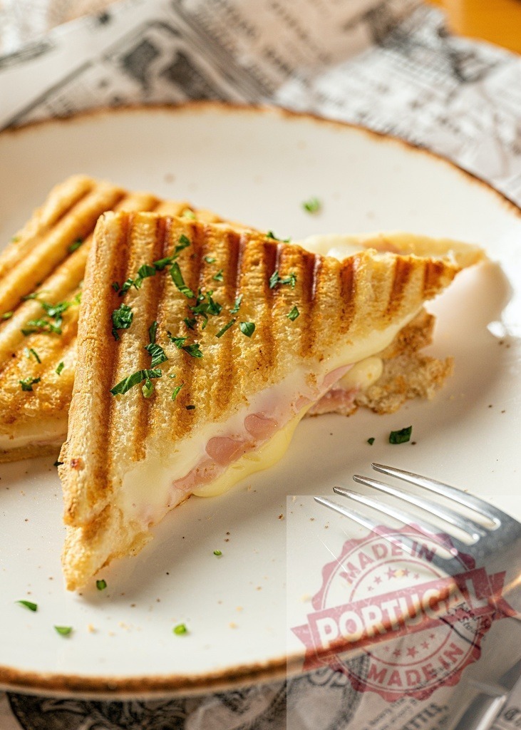 Grilled ham and cheese sandwich on white plate | Grilled ham and cheese sandwich on a plate, garnished with parsley - Realized with Pictrs.com