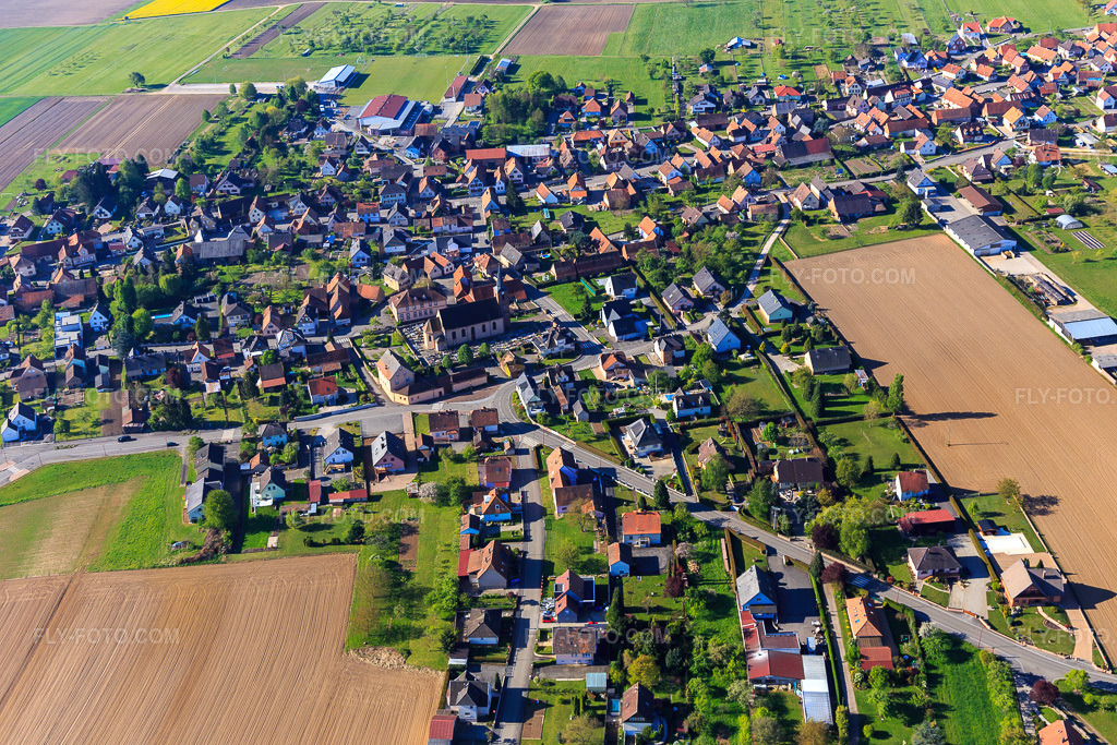 Aerial view: Eglise and cemetery de Eschbach and École élémentaire from the north in Eschbach in the state Bas-Rhin, France. – Photo: IMG_099373.jpg taken on 04/30/2017 by Werner Riehm/FLY-FOTO.com – Resolution of the original: 5472 x 3648 px