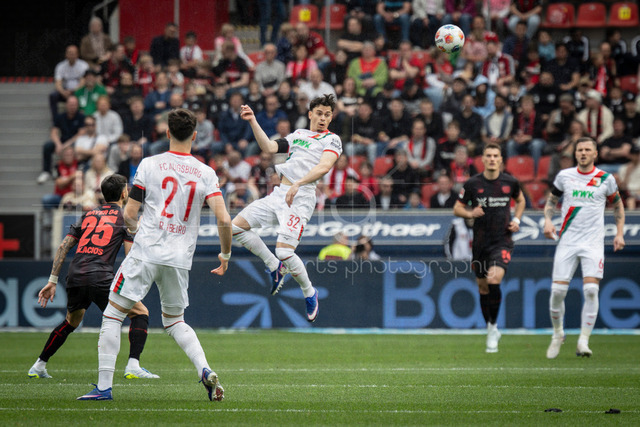 German Bundesliga, Bayer 04 Leverkusen vs. FC Augsburg, 18.04.2026 | LEVERKUSEN, GERMANY - APRIL 18, 2026 :  Fabian Rieder (FC Augsburg, 32) with a header during the German Bundesliga match on gameday 30 between Bayer 04 Leverkusen vs. FC Augsburg at BayArena on April 18, 2026 in Leverkusen, Germany. DFL REGULATIONS PROHIBIT ANY USE OF PHOTOGRAPHS AS IMAGE SEQUENCES AND/OR QUASI-VIDEO.