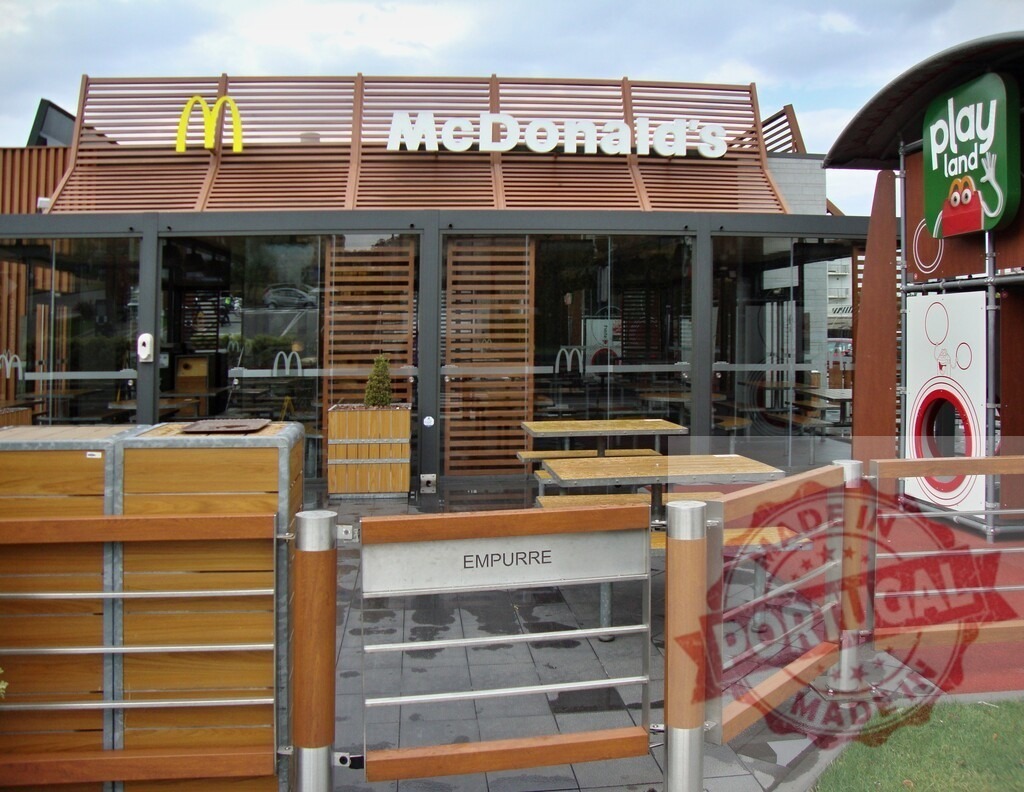 McDonald's restaurant exterior with Playland and outdoor seating area | McDonald's fast food restaurant building with Playland sign, outdoor tables, and modern architecture - Realized with Pictrs.com