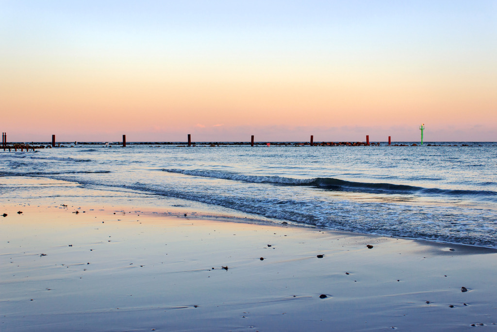 Wandbild: Abendrot an der Ostsee in Damp | Dieses Wandbild im Querformat zeigt die Ostsee im schönen Abendrot in Damp. Auf den nassen Bereichen des Sandstrands spiegelt sich der rötliche Abendhimmel.  - Realisiert mit Pictrs.com