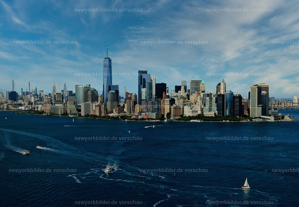 Manhattan Skyline unter blauem Himmel  | Die majestätische Manhattan Skyline erhebt sich unter einem strahlend blauen Himmel – ein Panorama, das die Kraft und Eleganz dieser Stadt verkörpert. Links glitzert der Hudson River wie ein flüssiger Spiegel, rechts schlängelt sich der East River durch die urbane Landschaft. Die Wolkenkratzer ragen stolz in den Himmel, ihre Glasfassaden reflektieren das Licht wie Diamanten. Es ist ein Moment purer Klarheit, in dem die Energie New Yorks und die Ruhe der beiden Flüsse in perfekter Harmonie verschmelzen – ein Bild, das Freiheit, Weite und die unendlichen Möglichkeiten dieser Metropole spüren lässt.