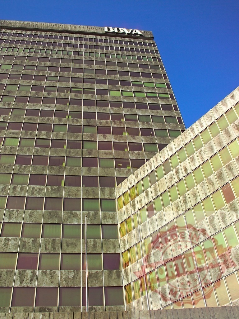 BBVA Tower in Buenos Aires city architecture. Spain - Bilbao | Concrete facade and glass windows on a modern corporate office building against blue sky - Realisiert mit Pictrs.com