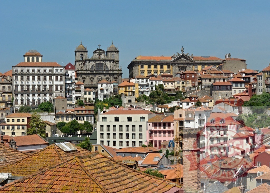 Porto cityscape with historical buildings and rooftops in Ribeira. Porto - Portugal | Porto's historic center with traditional tile rooftops under clear blue sky - Realisiert mit Pictrs.com