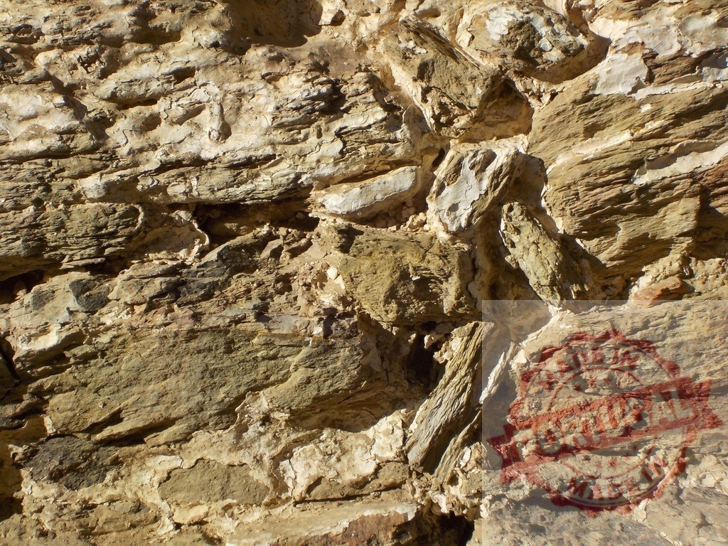 Rough textured surface of an old stone wall showing weathering and erosion | Close-up view of a weathered stone wall, highlighting the rough texture, natural colors, and effects of erosion - Realized with Pictrs.com