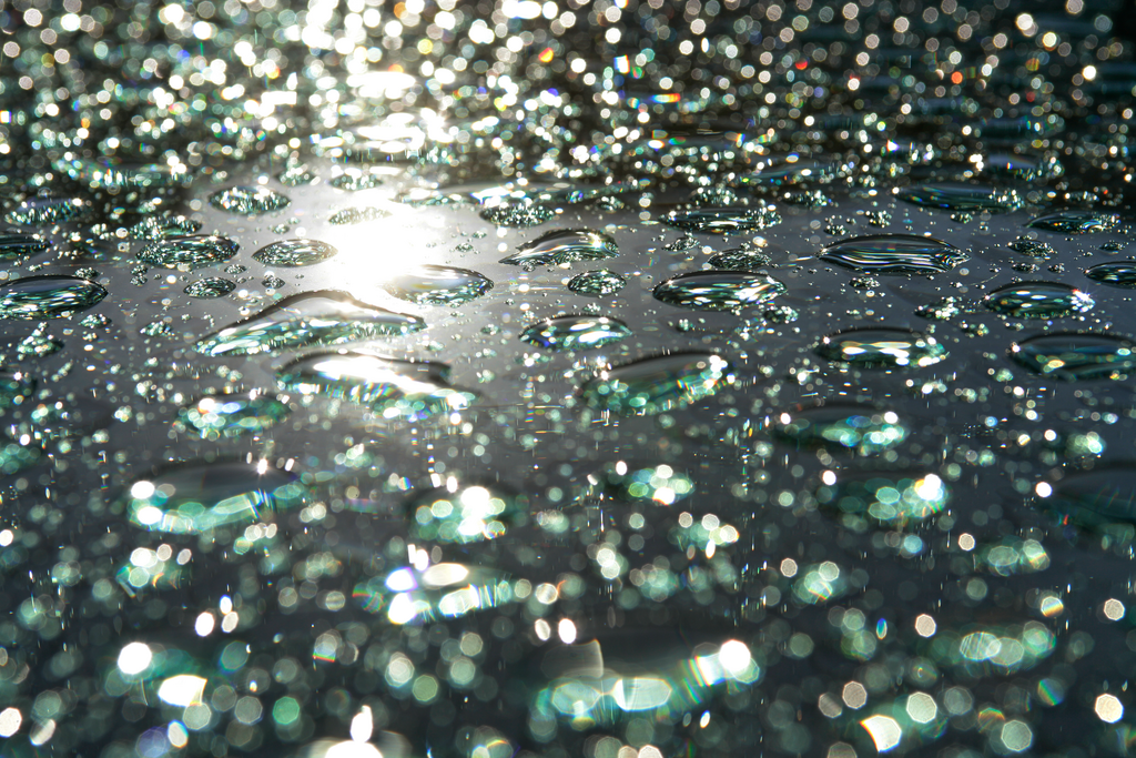 Wasser_8821Juli 10 2023 | Wassertropfen auf Grüm-Glasscheibe