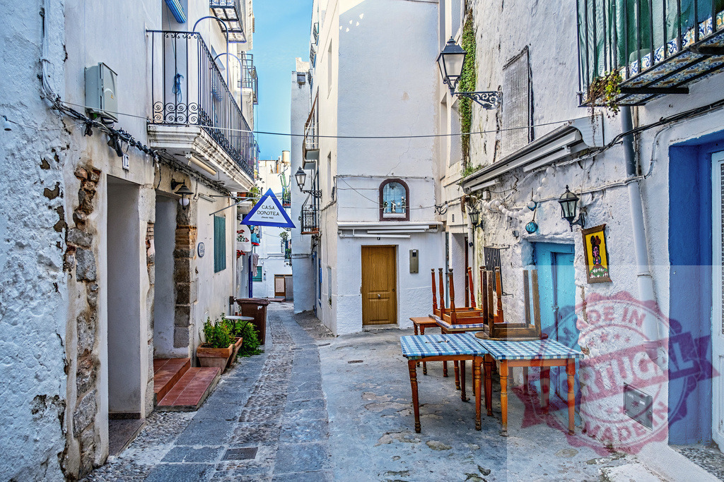 Spanish alley with whitewashed buildings and tables | Narrow alleyway winding through a traditional Spanish town with whitewashed architecture and tables - Realisiert mit Pictrs.com