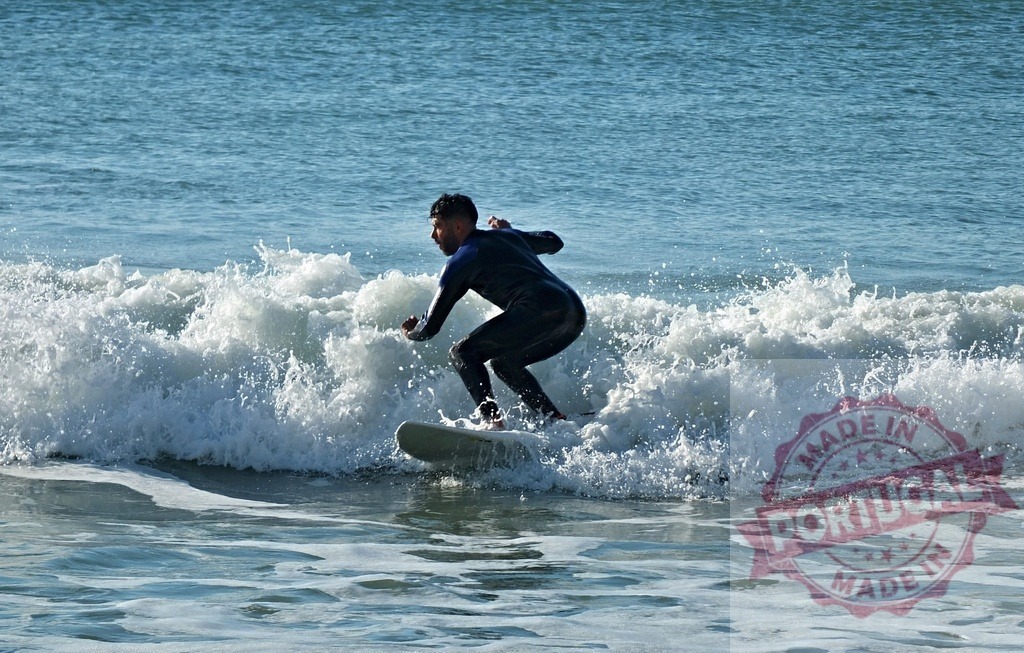 Male surfer riding ocean wave on surfboard | Young man in wetsuit surfing dynamic wave, displaying balance and extreme sport lifestyle - Realisiert mit Pictrs.com