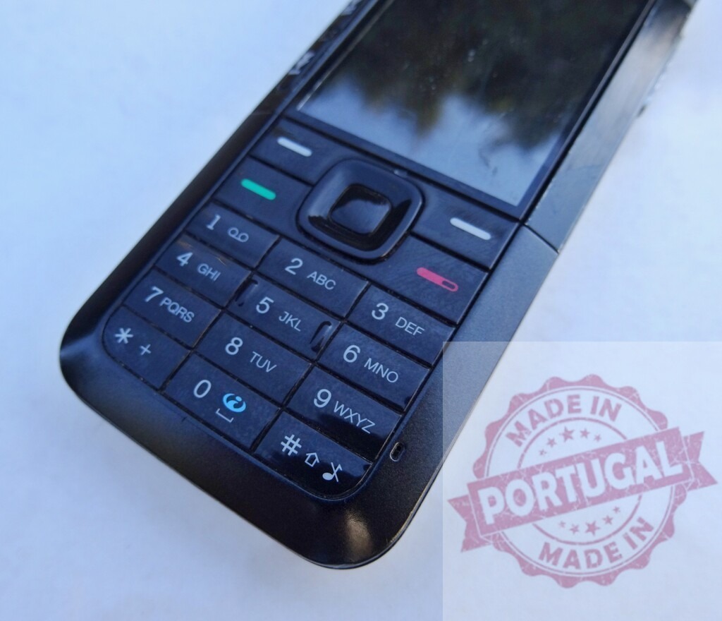 Nokia mobile phone showing keypad and scratched screen on white background | Close-up of an old Nokia cell phone highlighting its keypad and a damaged screen, evoking nostalgia for simpler technology - Realisiert mit Pictrs.com