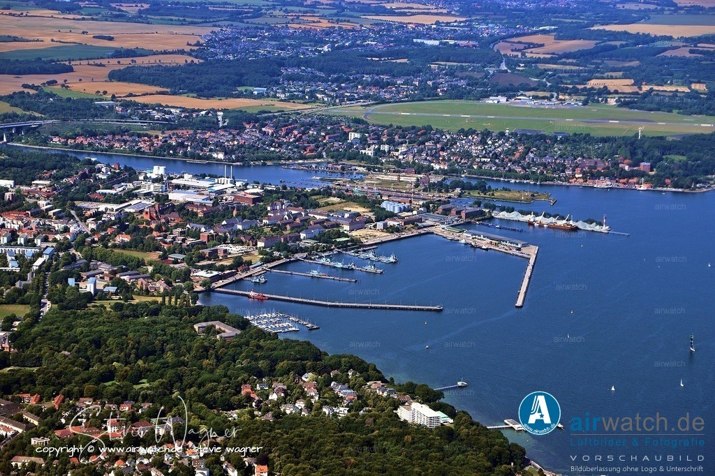 Luftbild Kiel Hafen - Aufstieg zum Reichskriegshafen 1865 | Aufstieg zum Reichskriegshafen 1865: Mit der Verlegung der preußischen Marinestation der Ostsee von Danzig nach Kiel begann der gezielte Ausbau zum Militärstandort.1871: Nach der Reichsgründung ernannte Kaiser Wilhelm I. Kiel zum Reichskriegshafen. Dies löste ein enormes Bevölkerungswachstum aus (von 20.000 auf über 200.000 Einwohner bis zum Ersten Weltkrieg).1906: Der Stapellauf von U 1, dem ersten deutschen U-Boot, auf der Germaniawerft unterstrich Kiels technologische Führungsrolle.