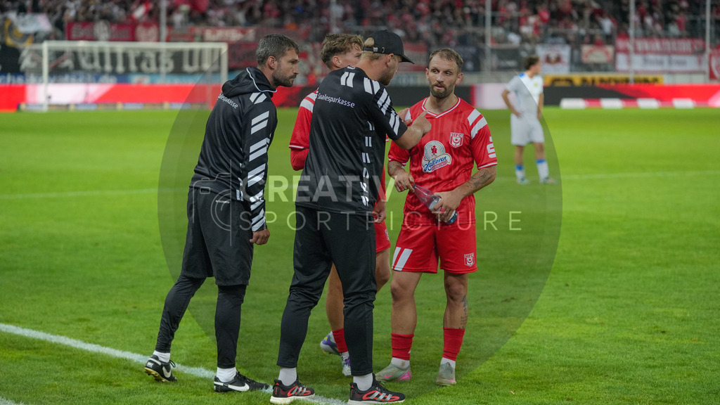 Fußball, Herren, Saison 2025/2026, Regionalliga Nordost, 5. Spieltag, Hallescher FC vs. FSV 63 Luckenwalde, Dienstag 26.08.2025, Leuna-Chemie-Stadion Halle, | Fußball, Herren, Saison 2025/2026, Regionalliga Nordost, 5. Spieltag, Hallescher FC vs. FSV 63 Luckenwalde, Dienstag 26.08.2025, Leuna-Chemie-Stadion Halle, Im Bild: Cheftrainer Robert Schröder und Co-Trainer Sascha Prüfer vom Halleschen FC mit Anweisungen an der Seitenlinie an Fatlum Elezi (r.) - Realisiert mit Pictrs.com