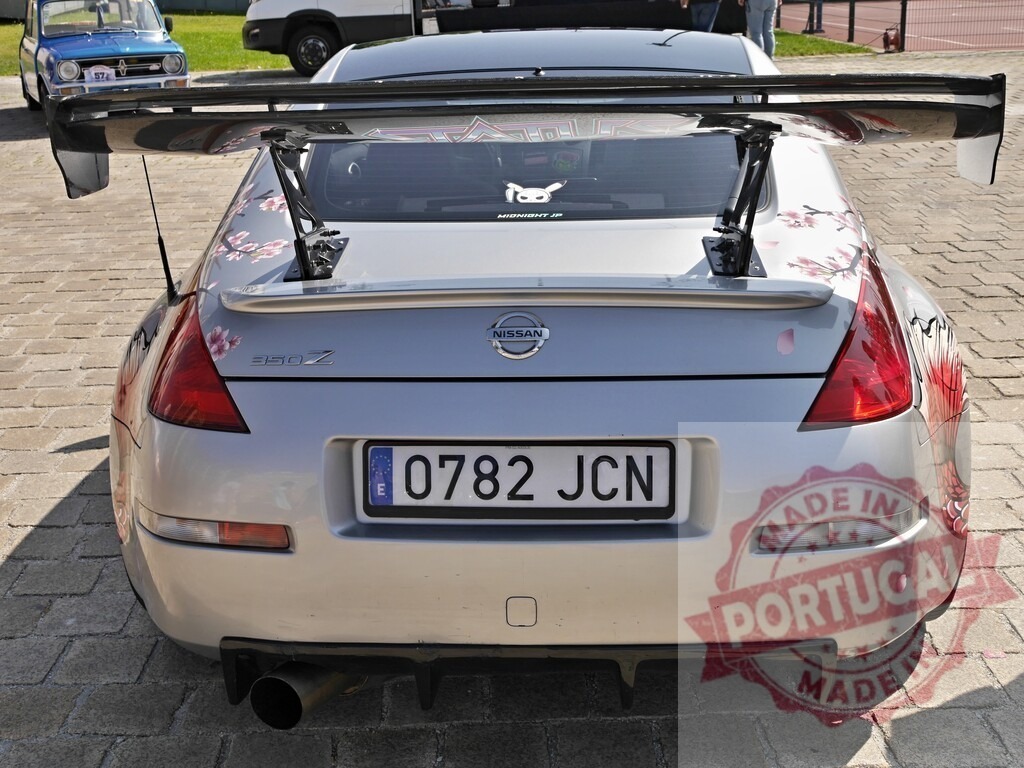 Nissan 350Z sports car rear view with sakura decal | Nissan 350Z sports car showing custom rear spoiler and cherry blossom decals - Realized with Pictrs.com