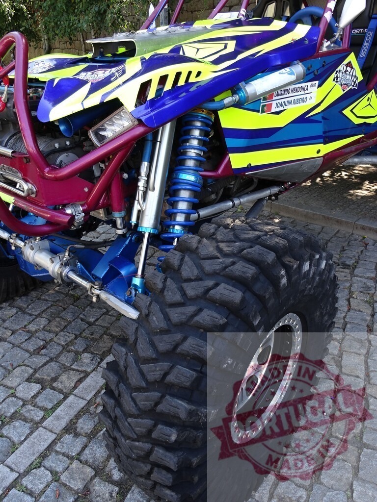 Powerful off-road buggy showing its suspension system and big tires | Close-up of a colorful buggy highlighting its robust suspension and large off-road tires, ready for an adrenaline-pumping adventure - Realized with Pictrs.com