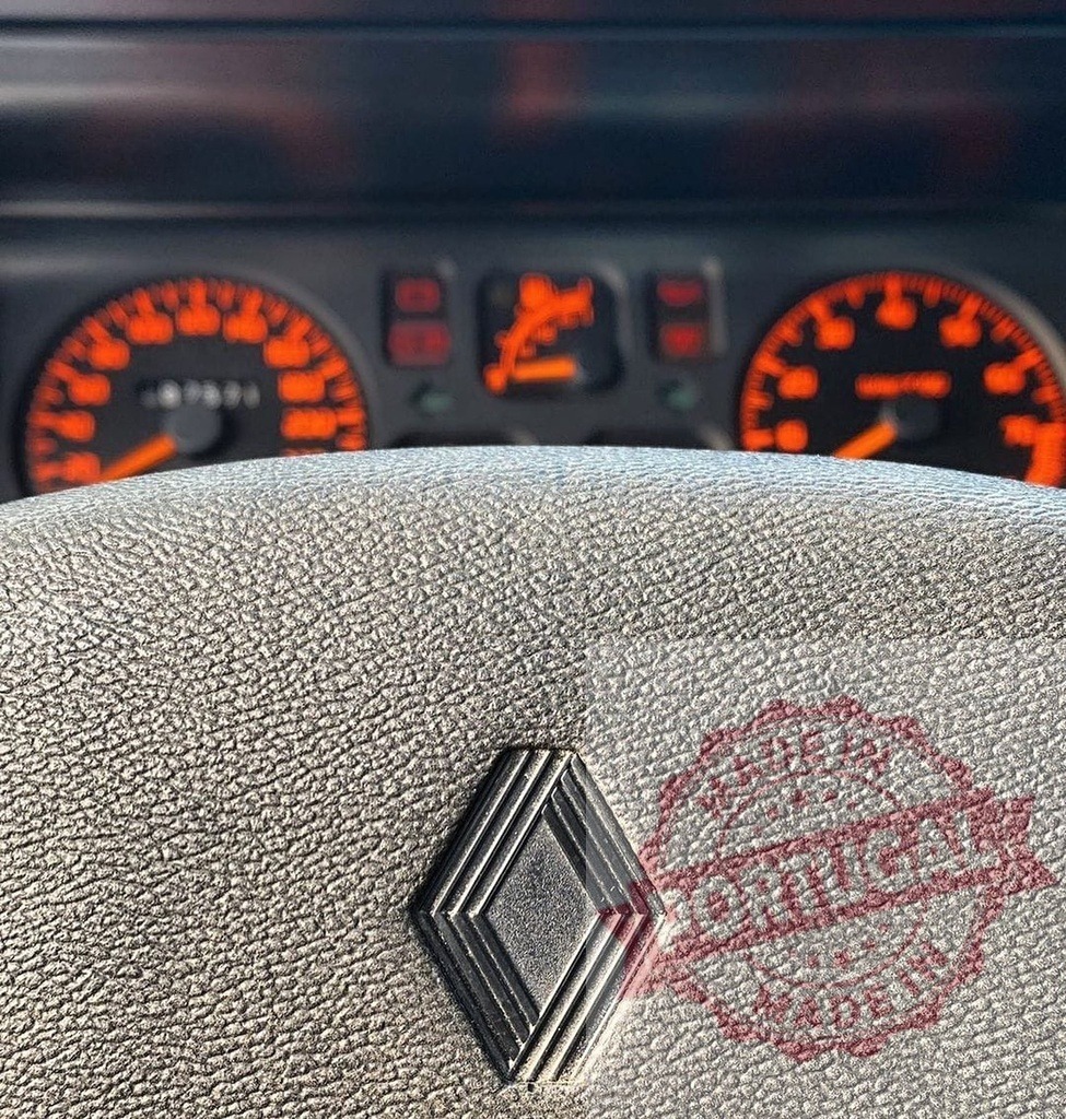 Renault car steering wheel with illuminated dashboard | Renault car steering wheel and dashboard with glowing orange instrument cluster - Realized with Pictrs.com