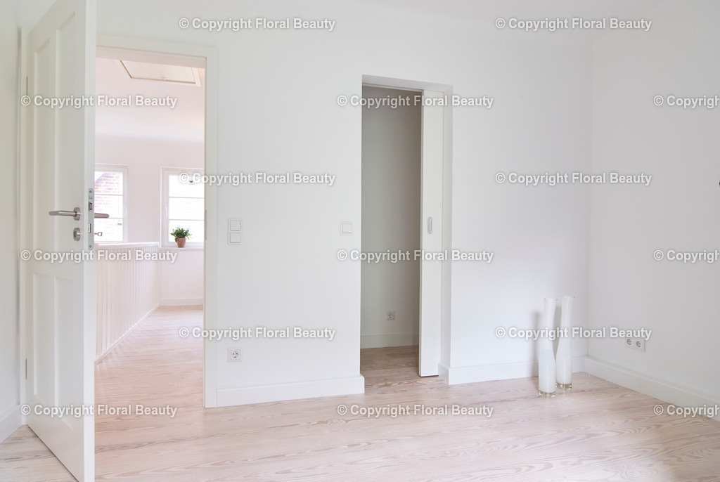 Umbau eines Rotklinkerhauses | breiter, grauer Sessel steht frei im Wohnzimmer mit Kuhfell und Kentiapalme - Realisiert mit Pictrs.com